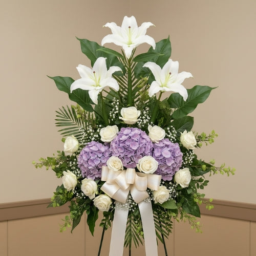 Floral arrangement with white lilies and purple hydrangeas on a beige background